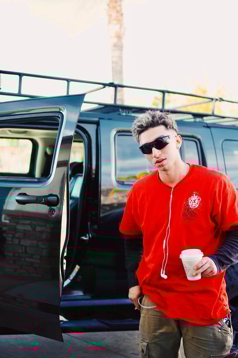 Romero Brothers - Young man in red jacket and sunglasses holding coffee cup
